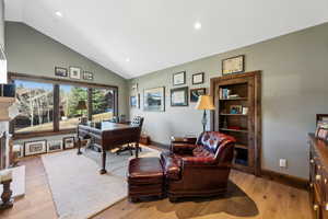 Office area featuring wood finished floors, recessed lighting, and high vaulted ceiling