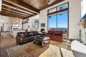 Living area featuring hardwood / wood-style flooring, a mountain view, and a wooden ceiling with exposed beams