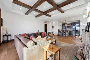 Living room with wood-type flooring, coffered ceiling, beamed ceiling, and recessed lighting