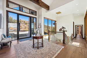 Sitting room featuring high vaulted ceiling, an upstairs landing, hardwood / wood-style flooring, beamed ceiling, and recessed lighting