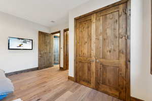 Unfurnished bedroom with light wood-type flooring and a closet