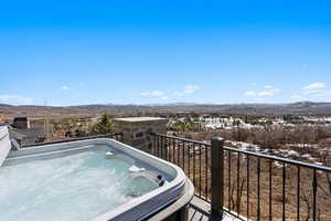 Balcony featuring a hot tub and a mountain view