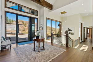 Foyer entrance with a high ceiling, hardwood / wood-style flooring, beamed ceiling, recessed lighting, and a mountain view