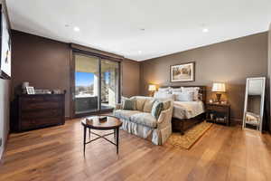 Bedroom with access to exterior, light wood-style floors, and recessed lighting