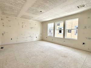 Empty room featuring a textured ceiling and baseboards