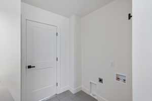 Laundry area with electric dryer hookup, hookup for a washing machine, and tile patterned floors