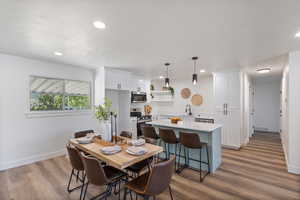 Dining space featuring wood finished floors, recessed lighting, and a textured ceiling