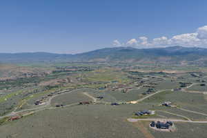Aerial view of property and surrounding area featuring a mountainous background