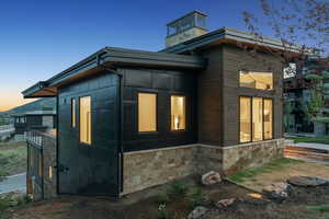 Property exterior at dusk featuring stone siding