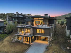 View of front facade featuring a balcony, driveway, and a garage