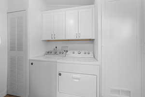 Laundry room featuring washing machine and clothes dryer and cabinet space