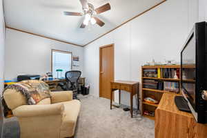 Office with vaulted ceiling, crown molding, carpet flooring, a textured ceiling, and a ceiling fan