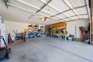 Garage with freestanding refrigerator and a garage door opener