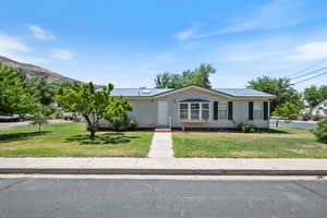 View of front facade with a front lawn and a metal roof