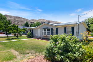 View of front of house with a front yard, a mountain view, and a metal roof