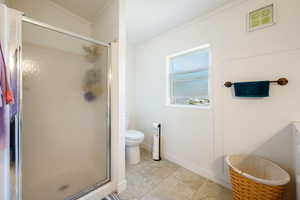 Bathroom with a shower stall and tile patterned floors