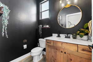 Half bathroom with vanity and wood finished floors