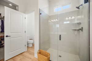 Full bathroom featuring wood finished floors and a shower stall