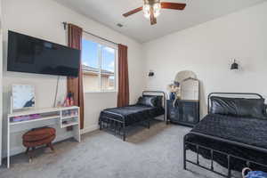 Carpeted bedroom featuring a ceiling fan and baseboards