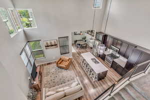 Living area featuring a towering ceiling and light wood-type flooring