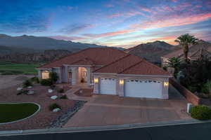 Mediterranean / spanish house featuring a mountain view, a garage, a tile roof, and driveway