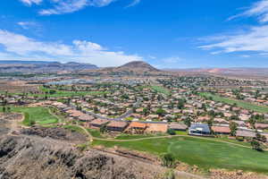 Aerial perspective of suburban area featuring a mountainous background and a golf course
