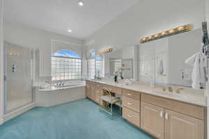 Bathroom with double vanity, a stall shower, a bath, and recessed lighting