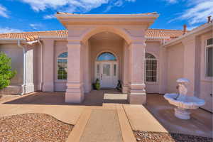 Property entrance with a tiled roof and stucco siding