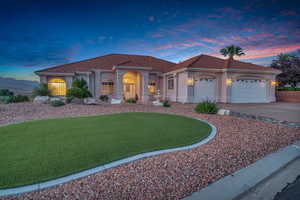 Mediterranean / spanish-style house with an attached garage, a tiled roof, concrete driveway, and stucco siding
