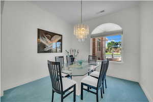 Dining room with ornamental molding, carpet floors, and a chandelier