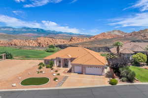 Mediterranean / spanish home with an attached garage, a mountain view, a tile roof, driveway, and stucco siding