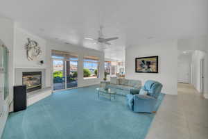 Tiled living room featuring arched walkways, a ceiling fan, a fireplace, and crown molding