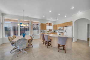 Kitchen with white appliances, a chandelier, light countertops, healthy amount of natural light, and recessed lighting