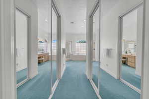Hall featuring carpet flooring, recessed lighting, and a textured ceiling