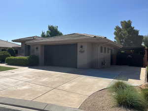 View of front of home with driveway, an attached garage, stucco siding, and a tile roof
