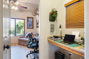 Office area with wood finished floors and a ceiling fan