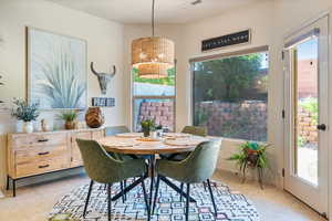 Dining area with light tile patterned flooring, healthy amount of natural light, and a chandelier
