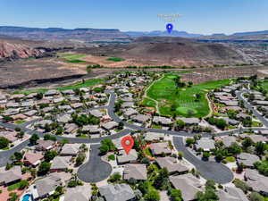 Aerial perspective of suburban area featuring a mountainous background and a golf course
