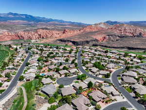 Aerial view of property and surrounding area featuring mountains and nearby suburban area