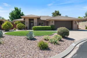 Prairie-style home with a tiled roof, an attached garage, concrete driveway, stucco siding, and a front yard