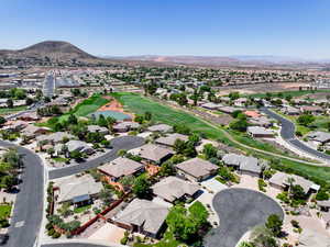 Aerial perspective of suburban area with a golf course and a water and mountain view