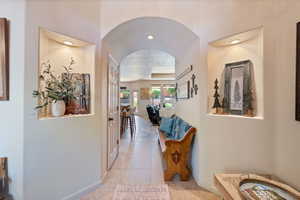 Corridor with arched walkways and light tile patterned flooring