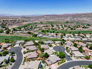 Aerial perspective of suburban area with mountains and a golf club