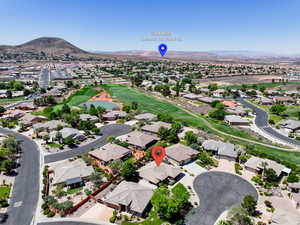 Aerial perspective of suburban area with a mountain backdrop and a golf course