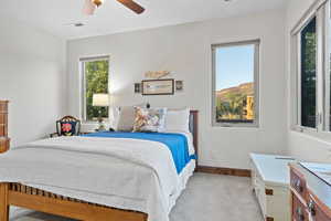 Bedroom with light colored carpet and a ceiling fan