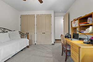 Office with ceiling fan and light colored carpet