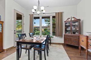 Dining room featuring a chandelier, plenty of natural light, and dark wood-type flooring