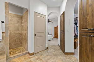 Bathroom with a walk in shower, a ceiling fan, connected bathroom, and a spacious closet
