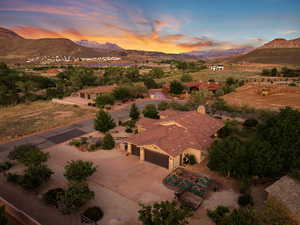 Aerial view of property and surrounding area featuring a mountainous background