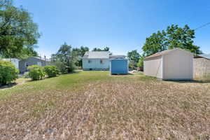 View of green lawn featuring a shed
